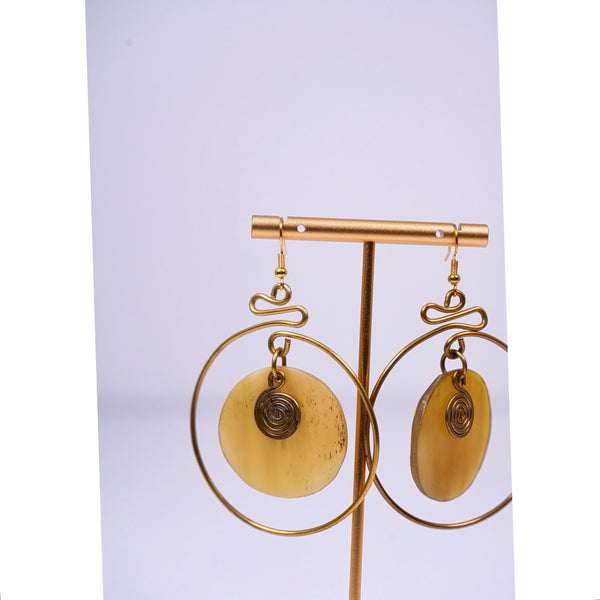 Yuri brass and bone dangling earrings with swirl detail.