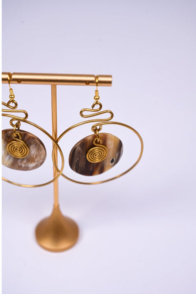 Yuri brass and bone dangling earrings with swirl detail.