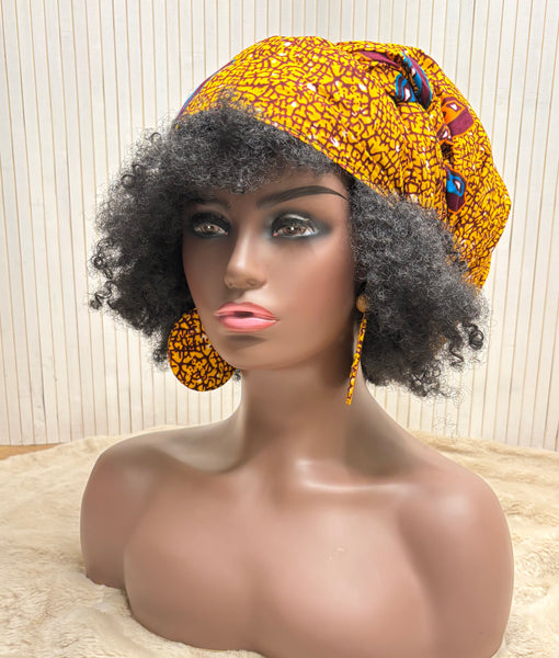 African print head wrap and large disc earrings in a mustard  print with dashes of multi colours.