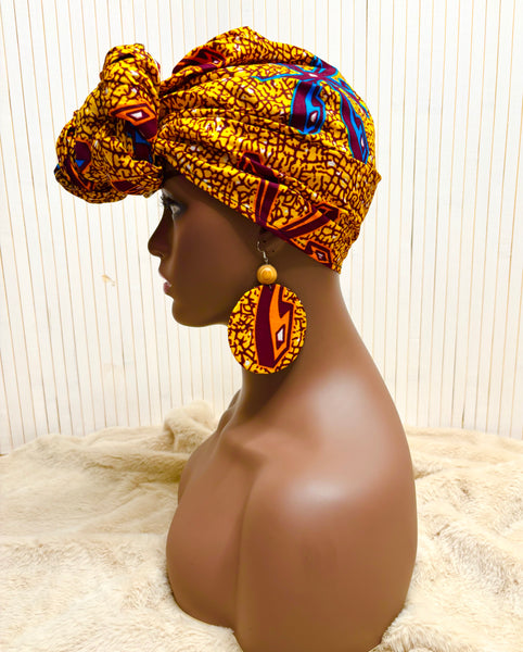 African print head wrap and large disc earrings in a mustard  print with dashes of multi colours.