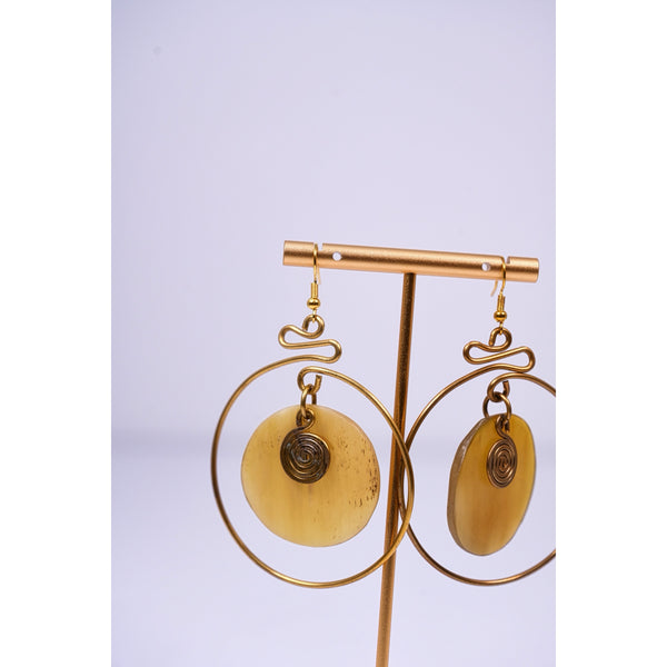 Yuri brass and bone dangling earrings with swirl detail.