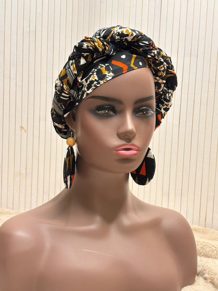 African print head wrap and large disc earrings in a multi colour geometric print with black.