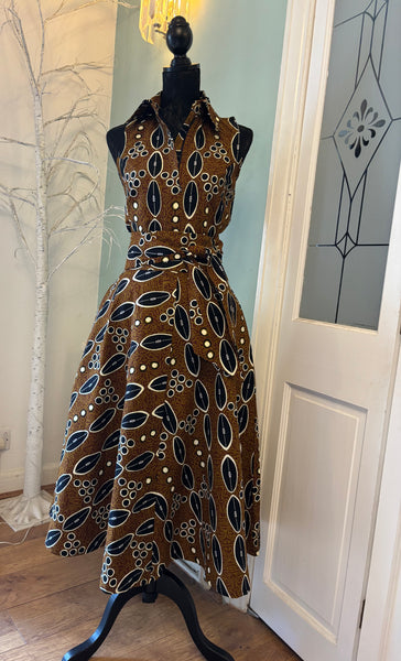 Shali sleeveless dress in a contemporary African print in brown.