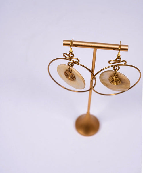 Yuri brass and bone dangling earrings with swirl detail.