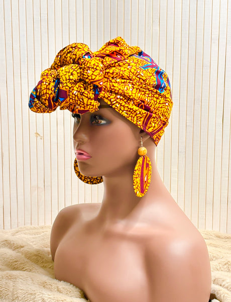 African print head wrap and large disc earrings in a mustard  print with dashes of multi colours.