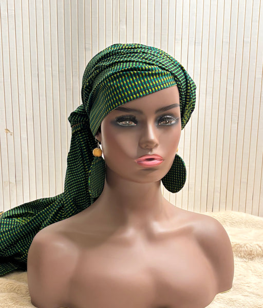 African print head wrap and large disc earrings in a green geometric print.