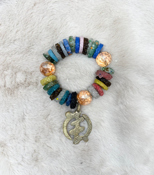 Recycled stretch glass bracelet with brass Adinkra symbols.