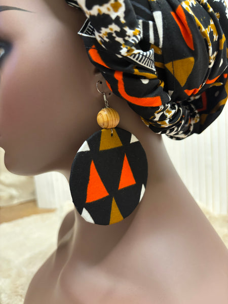 African print head wrap and large disc earrings in a multi colour geometric print with black.