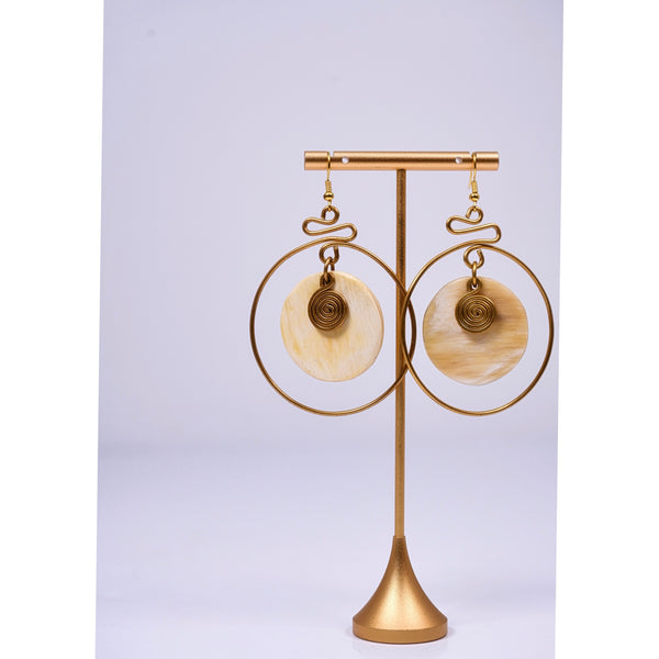 Yuri brass and bone dangling earrings with swirl detail.