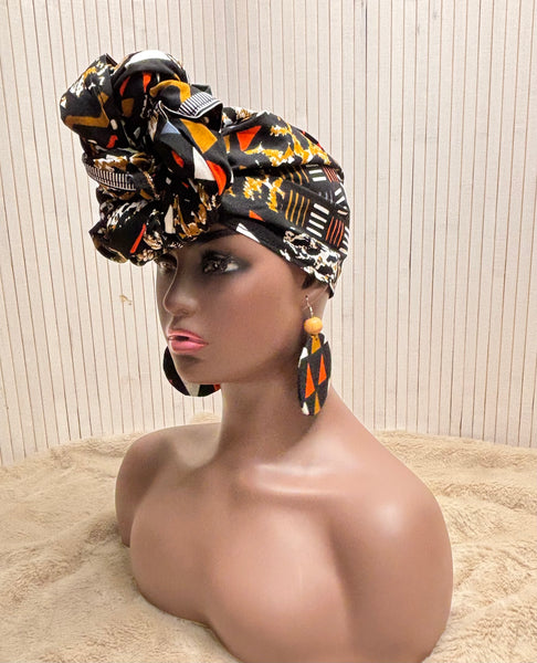 African print head wrap and large disc earrings in a multi colour geometric print with black.