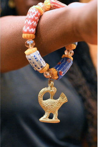 Stretch bracelet with traditional beads and Adinkra pendant.