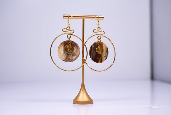 Yuri brass and bone dangling earrings with swirl detail.