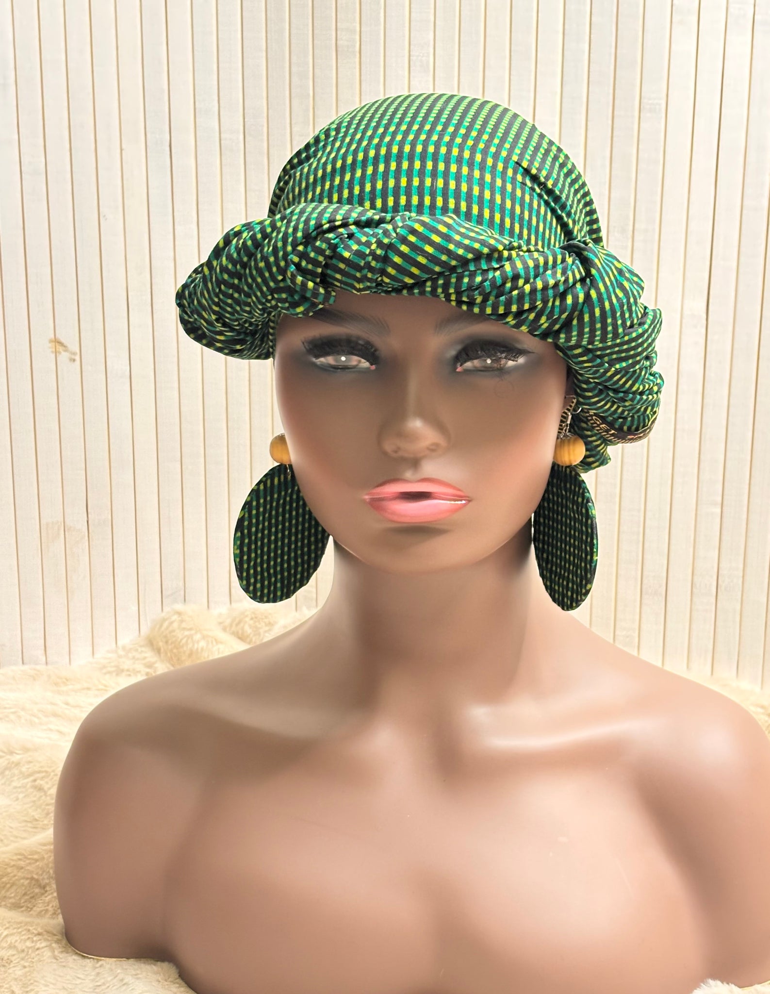 African print head wrap and large disc earrings in a green geometric print.