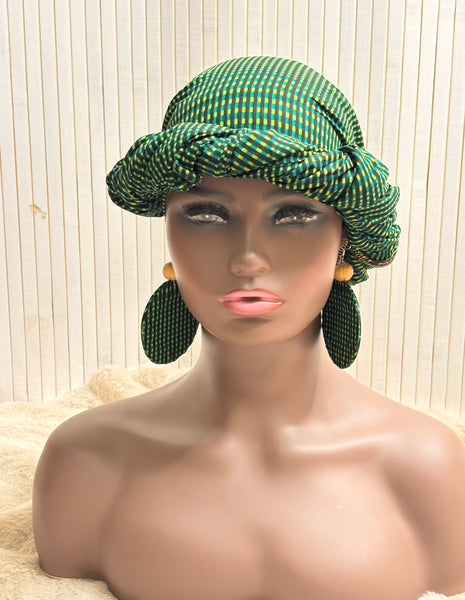 African print head wrap and large disc earrings in a green geometric print.