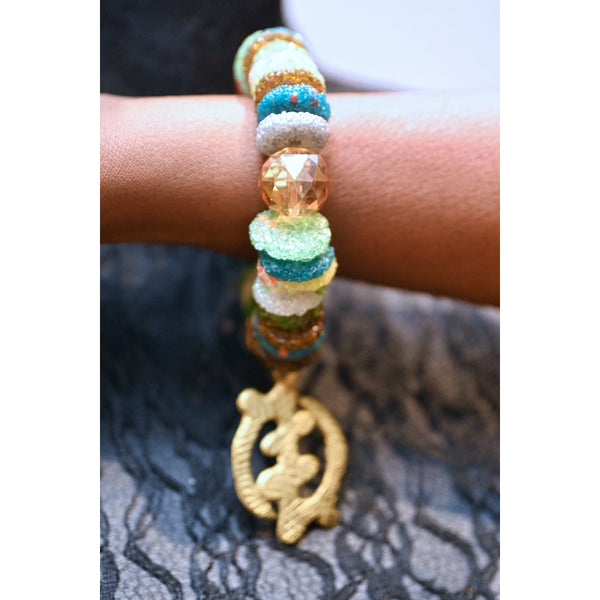 Recycled glass beads with adinkra pendant.